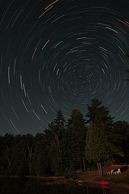 Great circles along which the stars travel in their course across the night sky. Time lapse image. Star Trails Shoreline.jpg