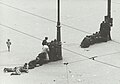 Menschen auf dem zentralen Platz Amsterdams, die während der Schießerei Schutz hinter Laternenpfählen suchen