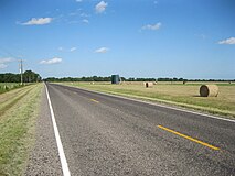 Baled hay and oil tanks can be seen along the eastern portion of FM 961.