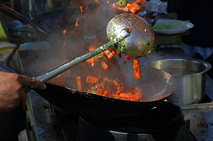 Stir frying (爆 bào) in the wok