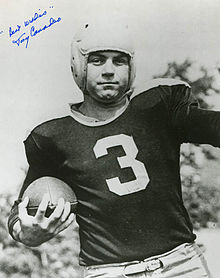 Black and white portrait of Canadeo in uniform holding a football