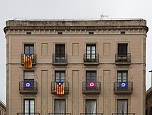 Foto eines Hauses mit ausgehängten Flaggen „Si“ und der Estelada