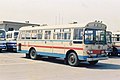 左のボンネットバスと同様の肌色を基調に横に青や赤のラインが入った旧式塗装車 トヨタDR15（西工42MC） ツーマン仕様