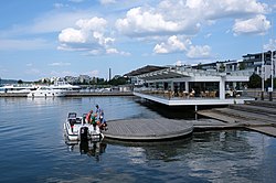 Piano-paviljongin suunnittelija sai inspiraatiota järviympäristöstä: paviljonki muistuttaa laivaa, jota ollaan laskemassa vesille, ja kattolipan haapariu’ut kuvastavat kalan ruotoja.