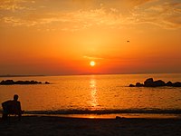 Stranden i Rometta mot Cape Milazzo och Eoliska öarna vid solnedgången.