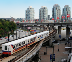 TransLink_SkyTrain_departs_Stadium-Chinatown_station_in_Vancouver,_British_Columbia,_Canada.png