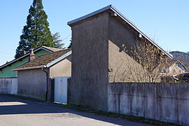 Deux petits bâtiments gris l'un avec un toit à deux pans l'autre à un seul pan.