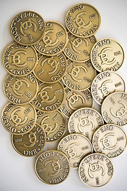 A pile of Breadcoins with side light making the coin markings stand out in sharp relief.