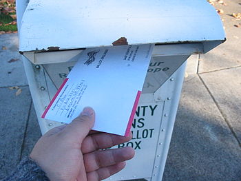 English: A voter returns his vote-by-mail ball...
