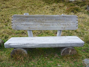 Wooden bench in memory of composer Hans Roelli in skiing area of Arosa, Switzerland