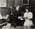 Avec John Cossar (à g.) et Anne Leigh, dans The Alster Case (1915)