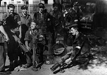 Polish insurgents in the Wola district recover PIAT anti-tank weapons from air-dropped containers. Warsaw Uprising - Baon Czata with PIAT guns.jpg