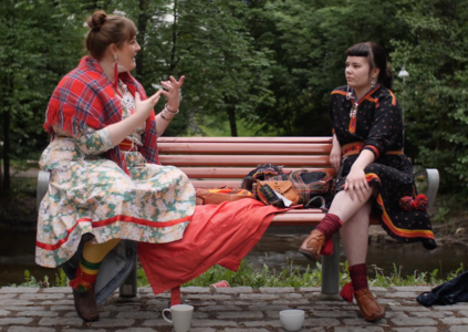 Maria Karlsen in conversation with Liisa-Rávná Finbog. Both wearing traditional gáktis. Screenshot from film.
