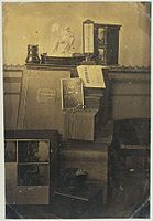 Zátiší s fotografiemi v albu, objektivem, sádrovou soškou Ariadne, teploměrem a časopisem Revue Photographique, asi 1855