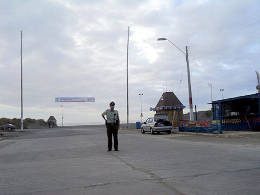 Un officier de police empêche les gens d'accéder à la Costanera, la rue la plus proche de la plage.