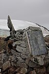 Steinhügel mit der Nachbildung einer Gedenktafel auf dem Megalestris Hill der Petermann-Insel, errichtet 1909 von der zweiten französischen Expedition unter Leitung von Jean-Baptiste Charcot. Das Original der Gedenktafel befindet sich in den Beständen des Muséum national d’histoire naturelle in Paris.