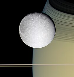 A Dione a Szaturnusz előtt. A képet a Cassini űrszonda készítette 39 000 km távolságból (2005. október 11.)