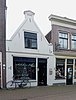 Winkel/woonhuis met gepleisterde tuitgevel met schouderstukken, tuit met fronton, 5 muurankers en zadeldak (Gouda-Centrum)