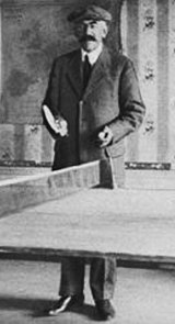 랑글렌의 아버지, 샤를 랑글렌이 테니스 테이블 뒤에 서있는 모습