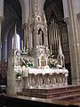 Autel richement décoré et orgue de chœur avec tuyaux peints.