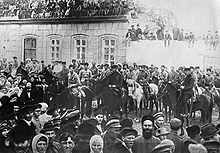 Des soldats à cheval, entourés d'une grande foule