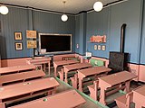 Skolepulter og tavle i klasserommet for småskolen. Foto: 2021