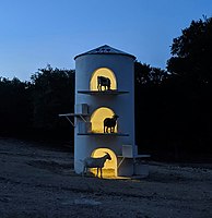 Goat tower at night with goats silhouetted on three levels