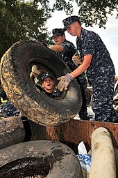 Navy sailors remove and dispose of used tires littering the waterways of a naval base in Charleston, South Carolina. US Navy 090917-N-1783P-001 Naval Nuclear Power Training Command student volunteers dispose of used tires littering the waterways of Naval Weapons Station Charleston.jpg