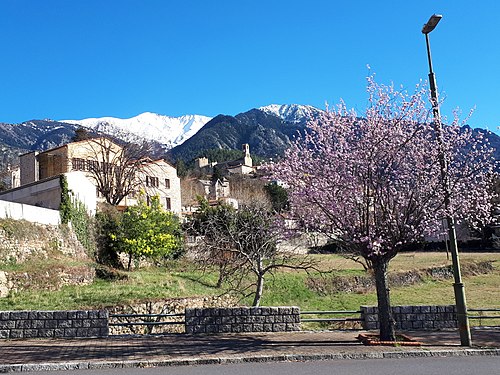 Vernet-les-Bains et les Pics du Canigou (à gauche) (2785m) et Quazemi (à droite). La faille de la Têt passe de gauche à droite derrière le village. Ce point de vue se situe à une altitude de 620m, à proximité de la rivière Cady. L'église se trouve au centre du village médiéval, qui repose lui-même sur des formations paléozoïques contenant du minerai de fer.