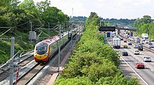 The West Coast Main Line railway, alongside the M1 motorway in Northamptonshire. WCML and M1.jpg