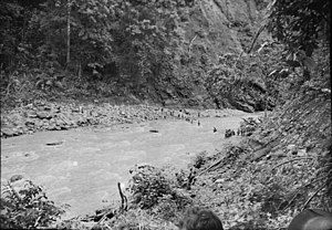 Кінець січня 1942 року. Австралійські солдати (праворуч у центрі) відступають з Рабаулу перетинаючи річку в горах на східній стороні півострова Газель. Фотограф: сержант Роббінс.