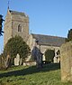 The west end of a stone church with a northwest tower surmounted by a saddleback roof