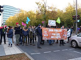 [[Extinction Rebellion]] protesters block a street in [[Germany]] holding a banner and signs