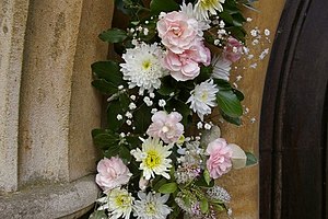 English: Flowers round church door at St John ...