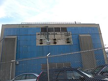 Power substation at 144th Place adjacent to a former section of the elevated tracks Jamaica 144 St BMT powerhouse scar jeh.jpg