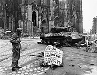 En amerikansk soldat läser en varningsskylt på en gata i Köln den 4 april 1945.