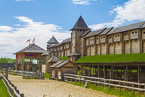a horse track in front of a large, wooden fort