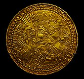 A Migration Period Germanic gold bracteate depicting a bird, horse, and stylized human head with a Suebian knot Bracteate from Funen, Denmark (DR BR42).jpg
