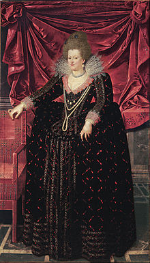 Old portrait of a standing woman very richly dressed with a white lace stand-up collar and pearls