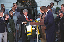 Brett Favre and Reggie White (front) present a Packers jacket to President Bill Clinton in May 1997. Green Bay Packers at White House 1997.jpg