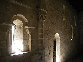 Interior of the church of São Pedro de Ferreira Monastery with small openings and carved capitals.