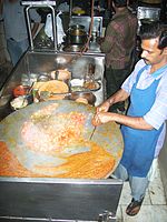 Pav bhaji đang được chuẩn bị trên chảo tava