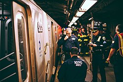 ESU officers investigate a subway suicide on the IND Queens Boulevard Line platforms at Lexington Avenue - 53rd Street. Subway suicide aftermath, E train on 53rd.jpg