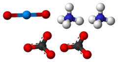 Ball-and-stick model of the component ions of ammonium uranyl carbonate, showing one uranyl cation (top-left), two ammonium cations (top-right) and two carbonate anions (bottom).