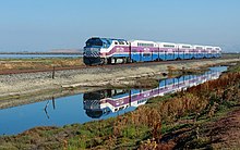 An Altamont Corridor Express train operating along the San Francisco Bay; a MPI F40PH-2C locomotive hauls a consist of Bombardier BiLevel Coaches. ACE EMD F40PH Fremont - San Jose.jpg