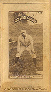 A man in a baseball uniform is crouched slightly with his hands on his knees.