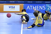 Three men wearing eye shades laying on the floor, a red ball is to the left of the image