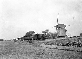 Nr. 7742 met rijtuigen onderweg tussen Bergen en Alkmaar bij de molen te Koedijk; 1953.