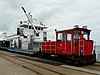 A Wangerooge Island Railway train in 2015 on the dock with freight being transferred between it and the ship docked there