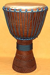 Коричневый кубковидный деревянный и кожаный барабан с синей веревкой на алебастровом фоне